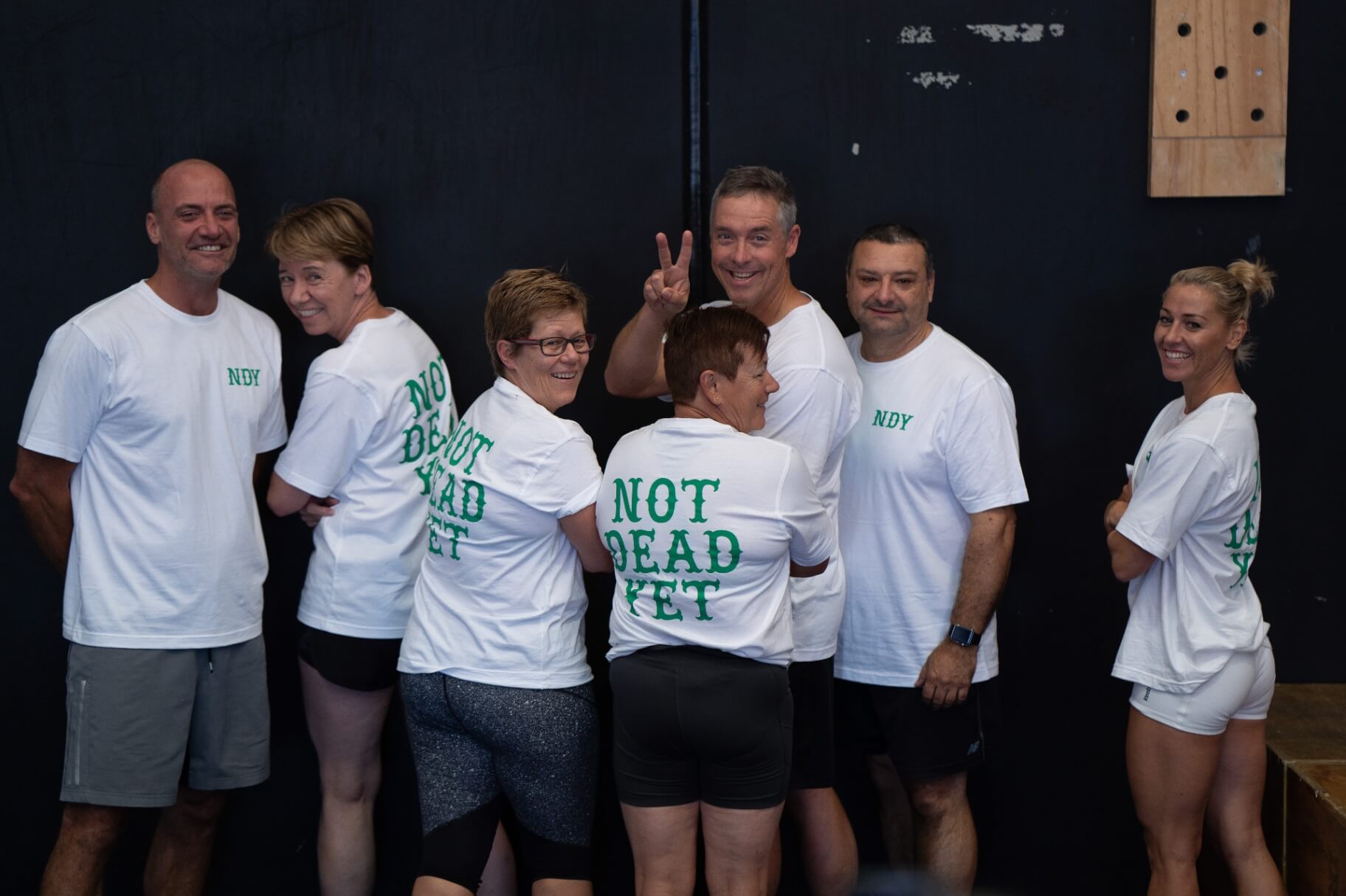 A group of long-time members laughing together in the gym