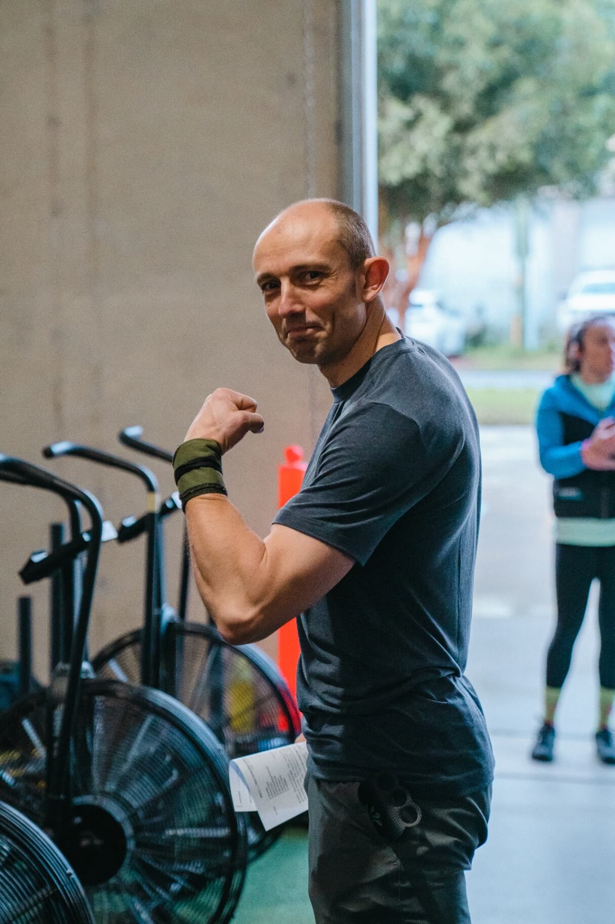 Member smiling and flexing after a session