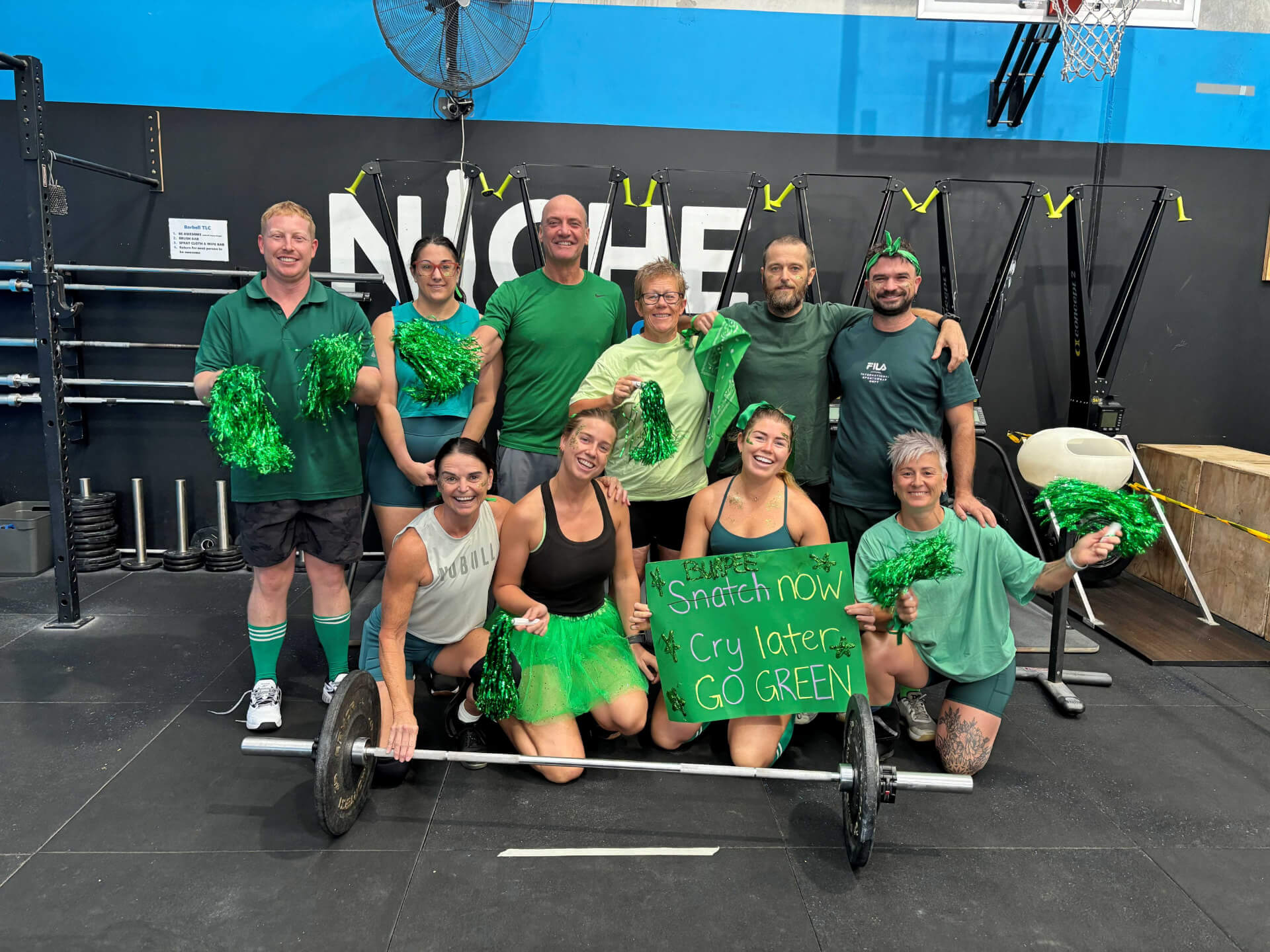 Members dressed in green with pom-poms for a community event