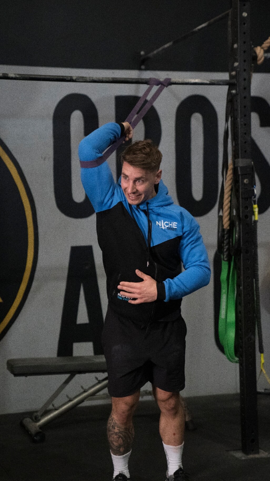 Member being coached through a banded shoulder stretch