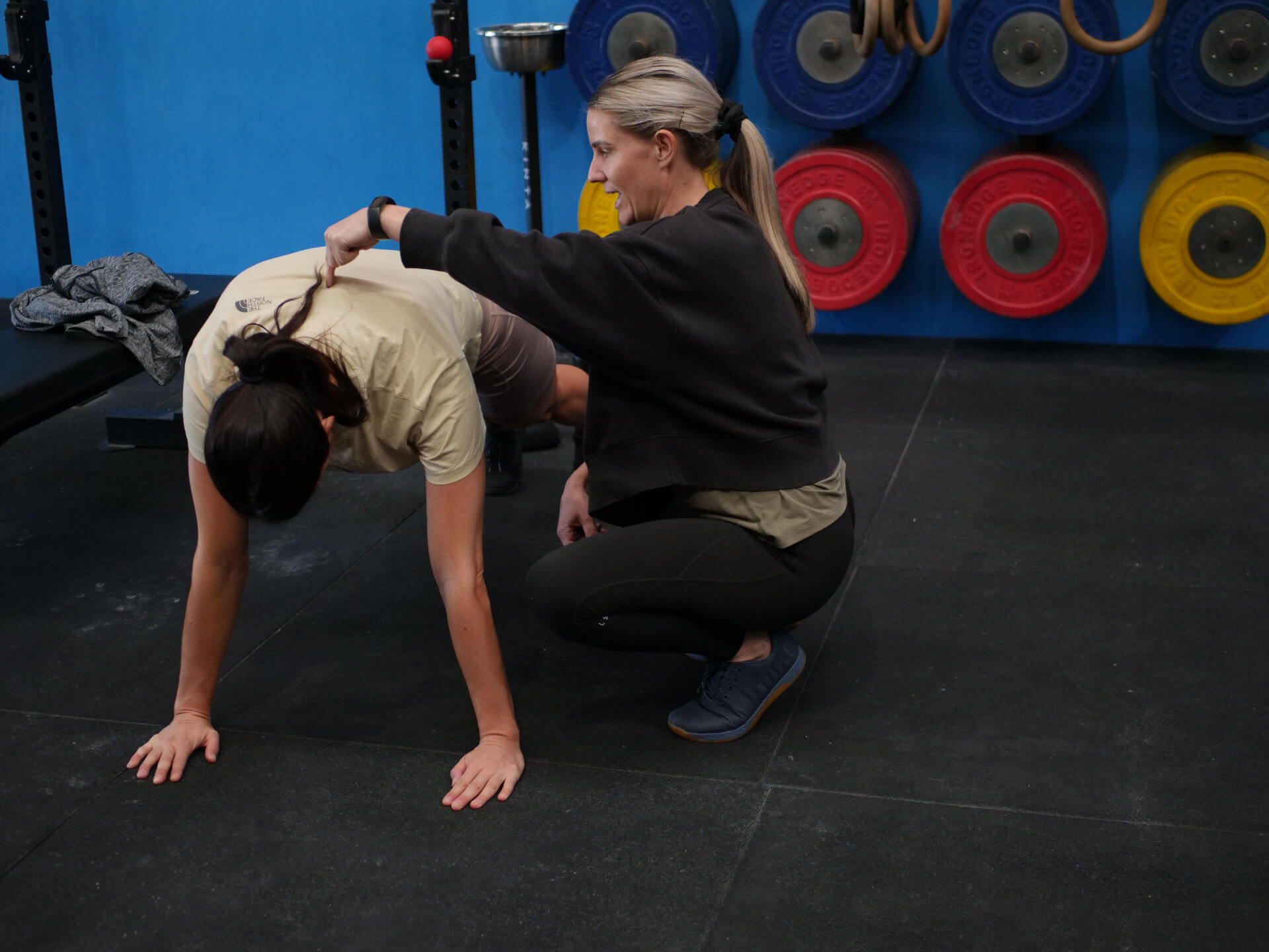 A coach giving hands-on cues to a member