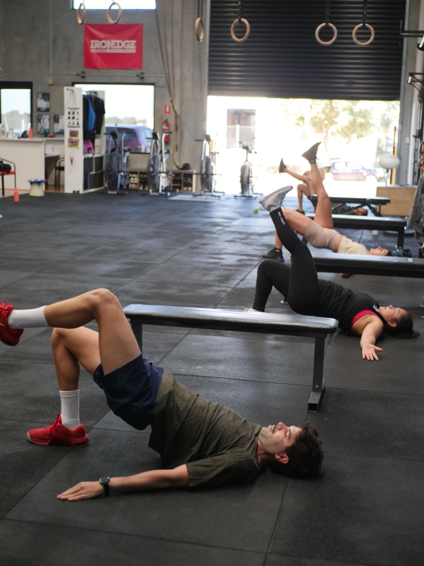 Members working through glute bridges on the benches