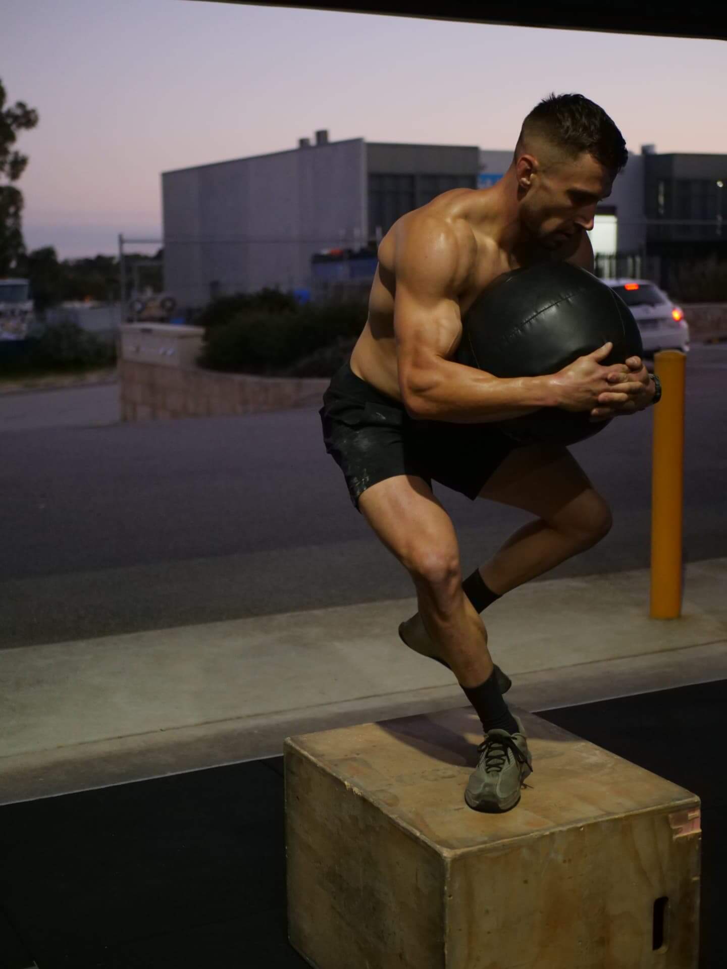 Member training with a wall ball at sunrise