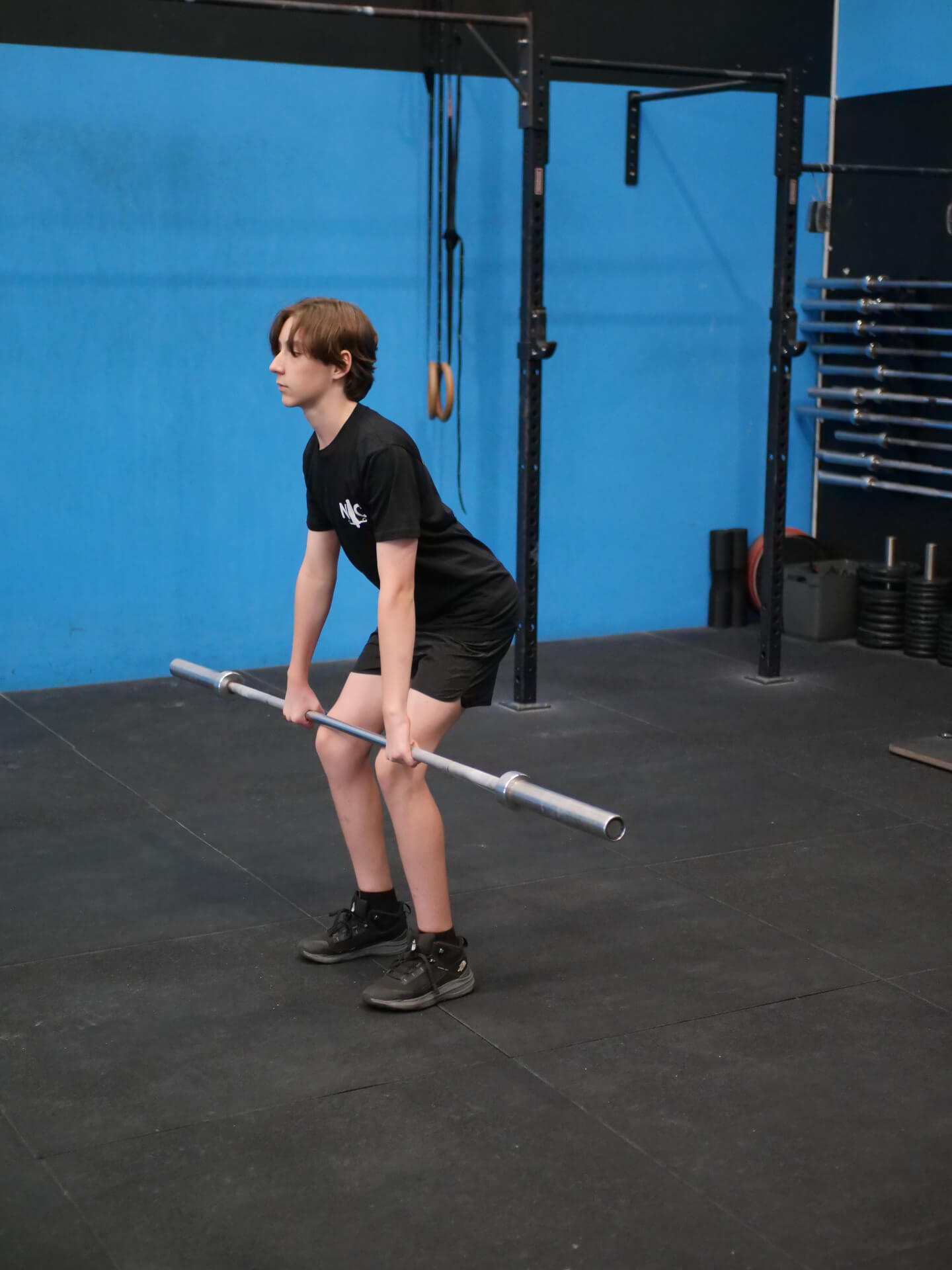 Teen athlete practising a barbell deadlift