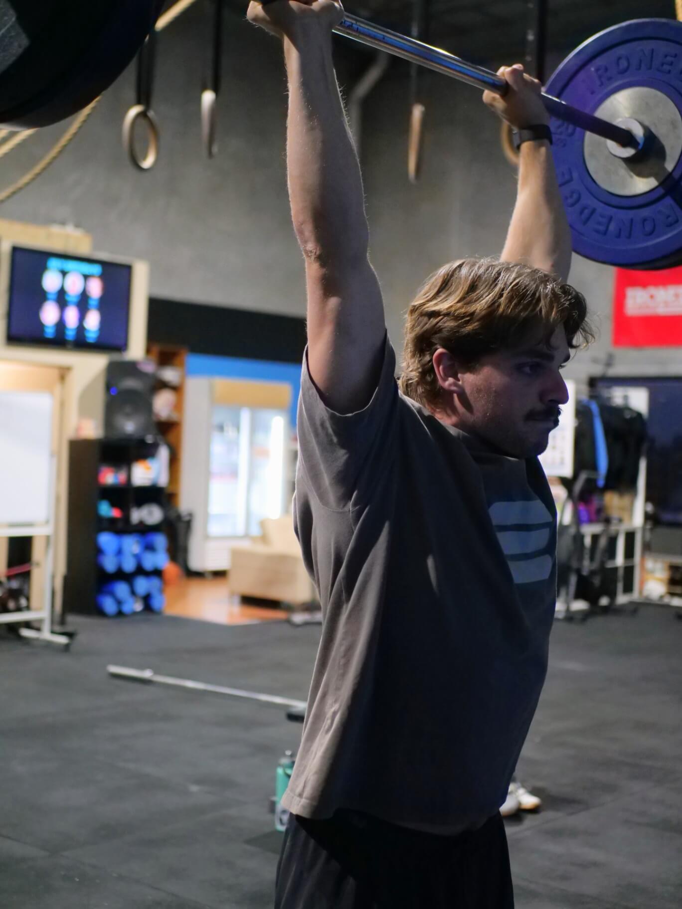 Member locking out an overhead press